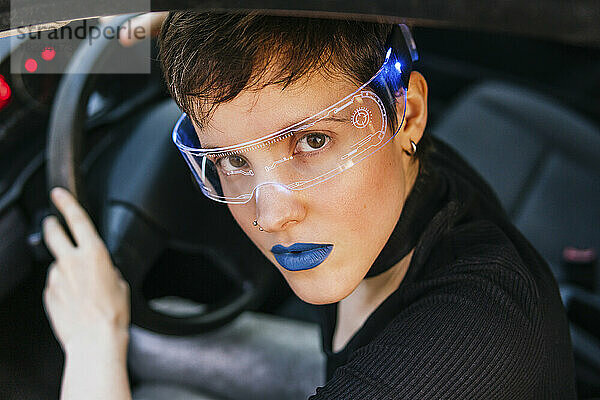 Frau mit blauem Lippenstift und Smart-Brille im Auto