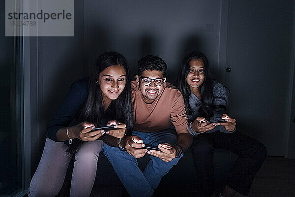 Happy man and women playing game at home