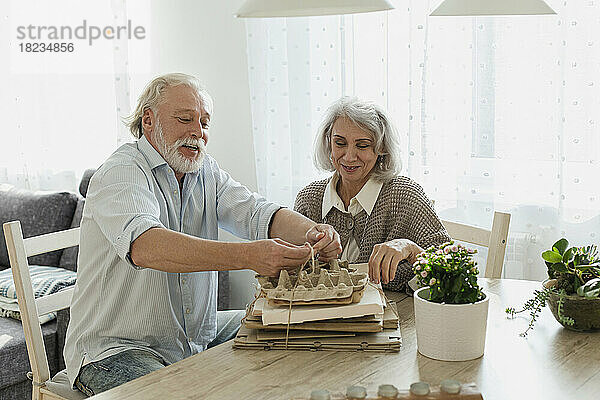 Älteres Paar bündelt zu Hause Altpapier