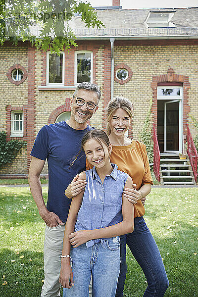 Glückliches Mädchen mit Mutter und Vater im Hinterhof