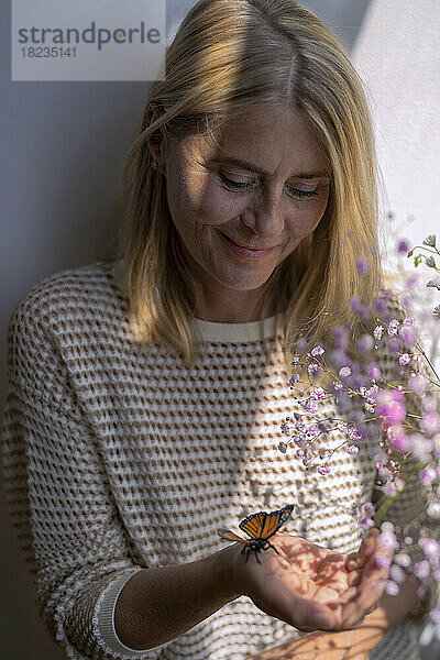 Reife Frau  die Schmetterling betrachtet