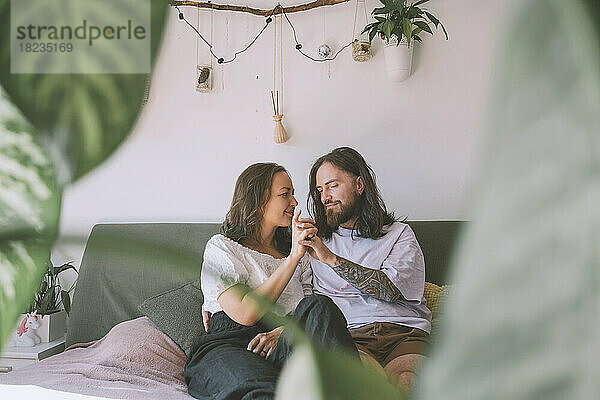 Happy romantic couple sitting on bed in at home