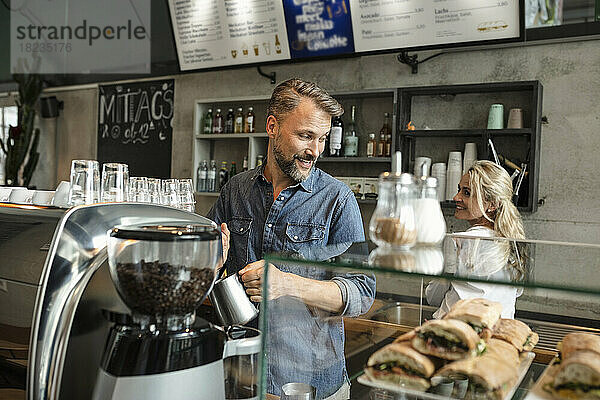 Barista dampft Milch an der Espressomaschine im Café