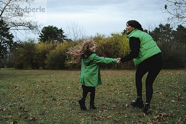 Glückliche Mutter mit Tochter  die Händchen hält und im Park genießt
