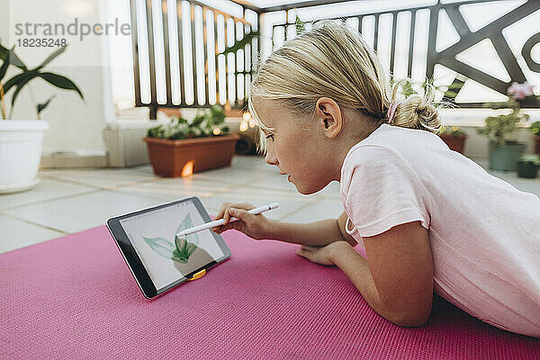 Mädchen zeichnet Blatt auf einem Tablet mit digitalisiertem Stift