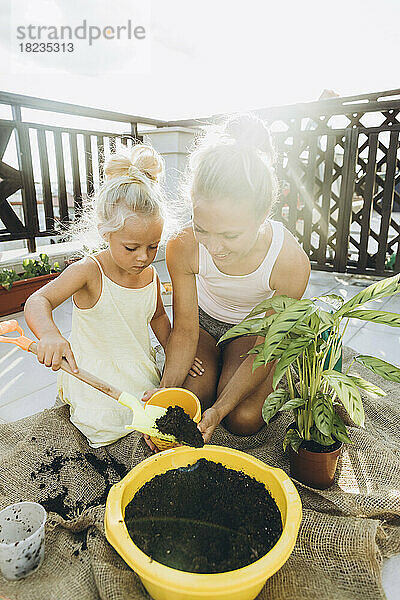 Mutter und Tochter pflanzen gemeinsam auf Dachterrasse