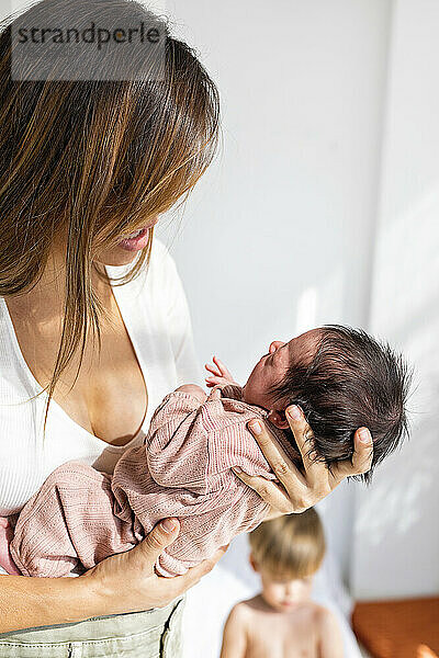 Mother holding newborn daughter at home