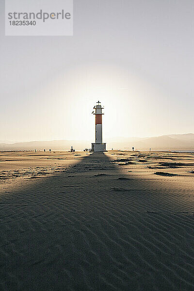 Schatten des Leuchtturms auf Sand am Strand