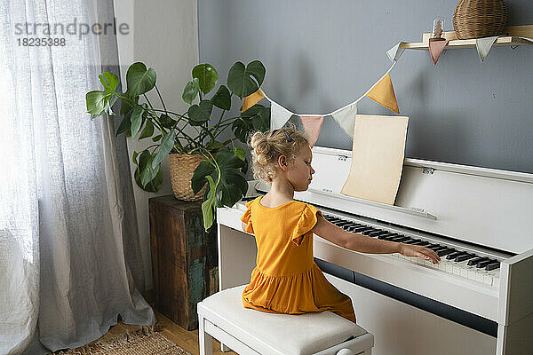 Mädchen übt zu Hause Klavier
