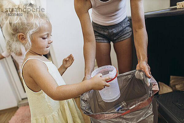 Mutter und Tochter sammeln Plastikmüll in der Küche