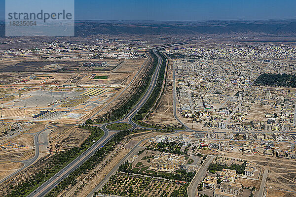 Oman  Gouvernement Dhofar  Salalah  Luftaufnahme einer langen Straße  die sich durch eine Wüstenstadt erstreckt