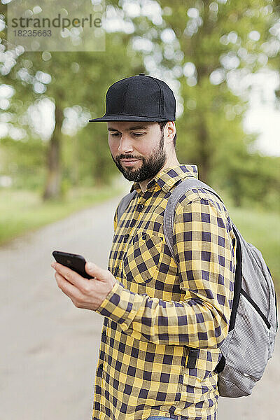 Mann schaut unterwegs auf sein Handy