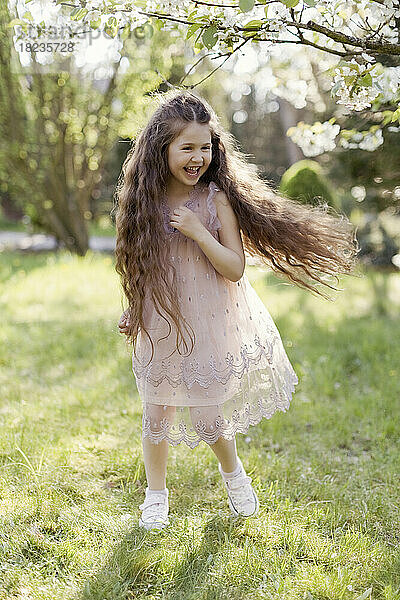 Fröhliches Mädchen läuft auf Gras im Park