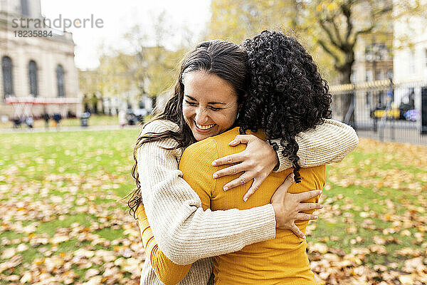 Frau umarmt Freundin im Herbstpark