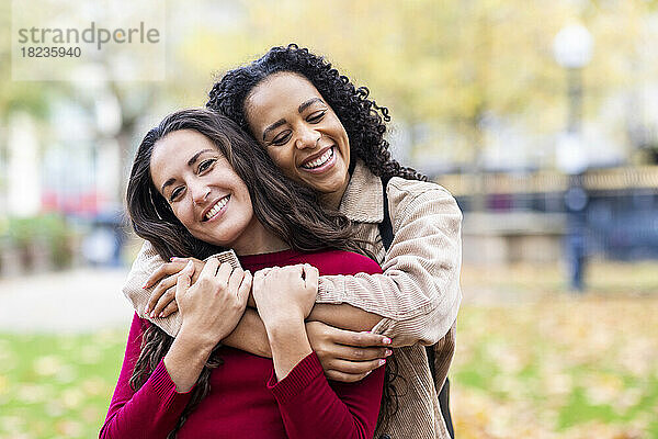 Frau umarmt Freundin im Park