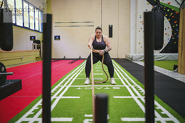 Junge Frau macht Crosstraining im Fitnessstudio