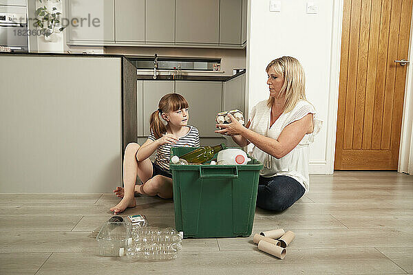 Mutter und Tochter recyceln Plastikflaschen und -behälter zu Hause