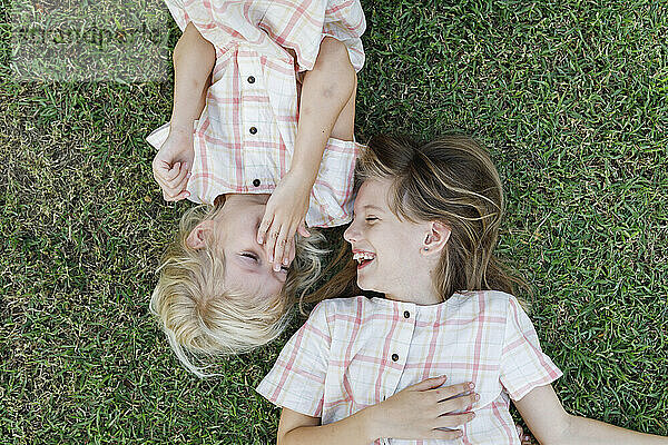 Glückliche Schwestern genießen es im Gras