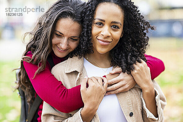 Woman embracing friend in park