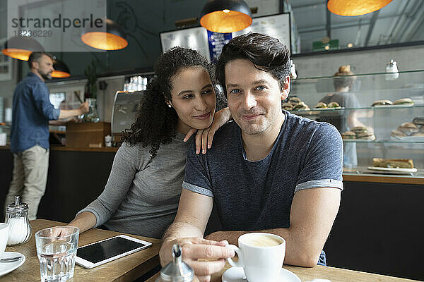 Lächelndes Paar sitzt im Café