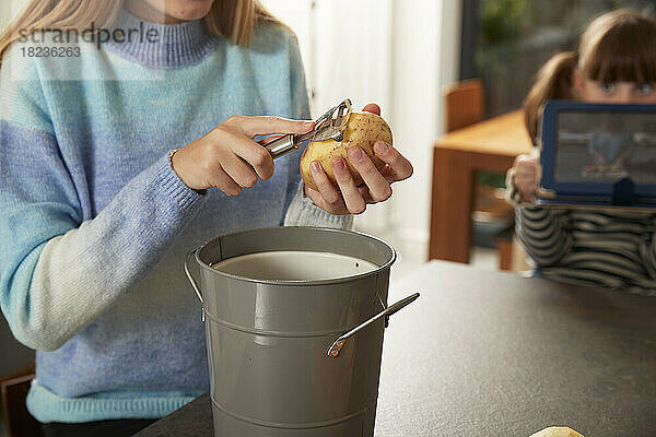 Mädchen schält Kartoffeln in der heimischen Küche