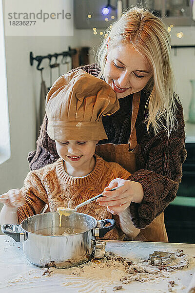 Glückliche Mutter und Sohn bereiten zu Hause Kekse zu