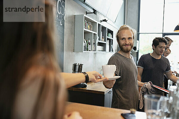 Barista serviert Kunden im Café Kaffee