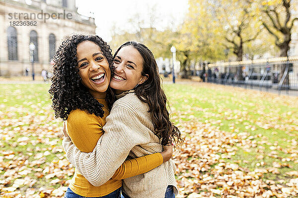 Glückliche Frauen umarmen sich im Herbstpark