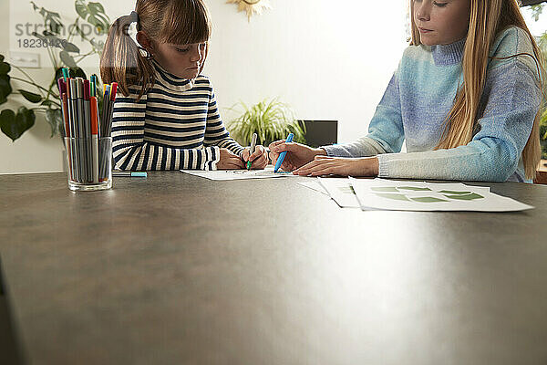 Mädchen zeichnen zu Hause mit Stift auf Papier
