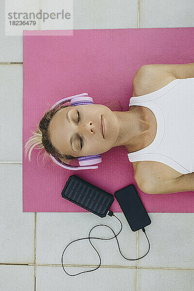 Woman with closed eyes listening to music with headphones and relaxing