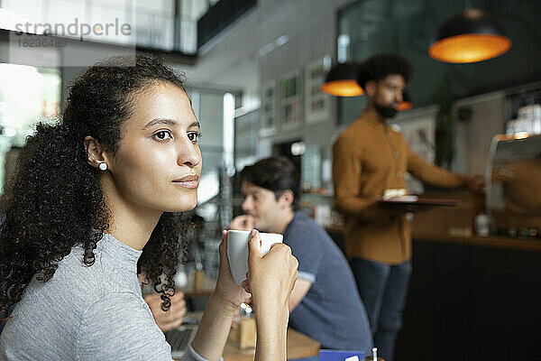 Nachdenkliche Frau mit Kaffeetasse im Café