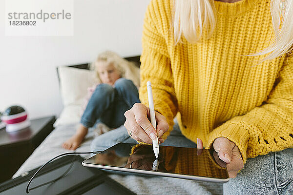 Frau benutzt Tablet-PC mit digitalisiertem Stift zu Hause