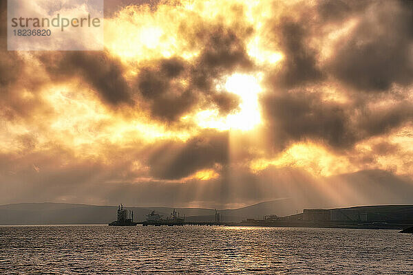 Großbritannien  Schottland  dramatischer Sonnenuntergang über Sullom Voe mit Ölterminal und Gasanlage im Hintergrund