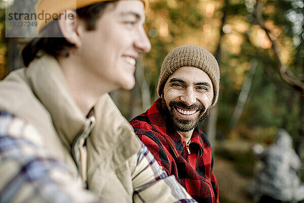 Porträt eines glücklichen Mannes mit einem jungen männlichen Freund beim Camping
