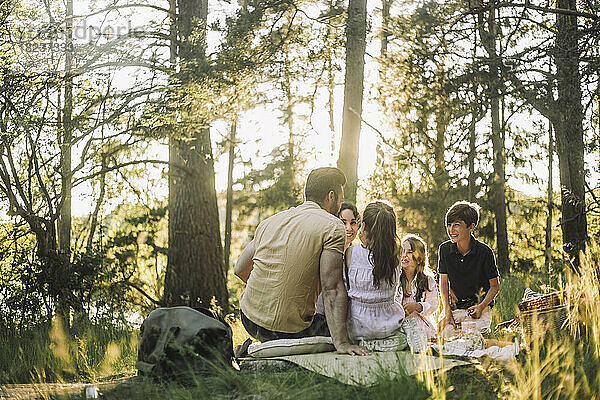 Glückliche Familie verbringt ihre Freizeit bei einem Picknick im Wald