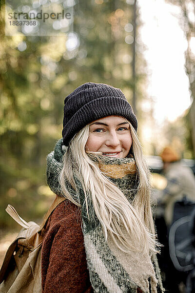 Porträt einer lächelnden blonden Frau mit Strickmütze
