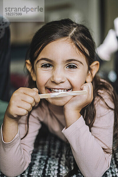 Porträt eines lächelnden Mädchens  das in einer Kindertagesstätte Eis isst