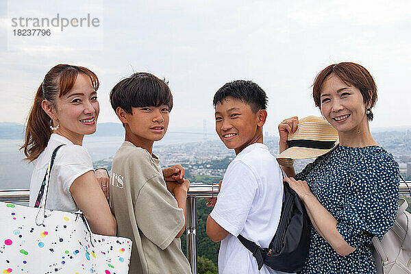 Vier Japaner auf einem Ausflug  zwei reife Frauen und zwei 13-jährige Jungen  hintereinander auf einer Aussichtsplattform.