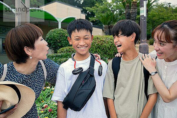 Vier Japaner auf einem Ausflug  zwei reife Frauen und zwei 13-jährige Jungen  hintereinander  lachend.