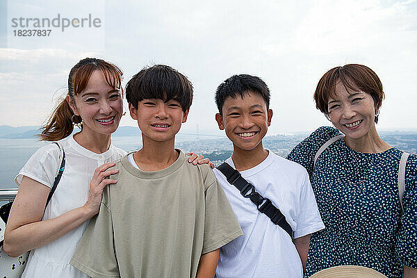 Vier Japaner auf einem Ausflug  zwei reife Frauen und zwei 13-jährige Jungen  hintereinander auf einer Aussichtsplattform.