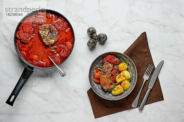 Langsam kochendes Essen. Ansicht von oben: Roastbeef in Biersoße mit Tomaten und Karotten gebacken