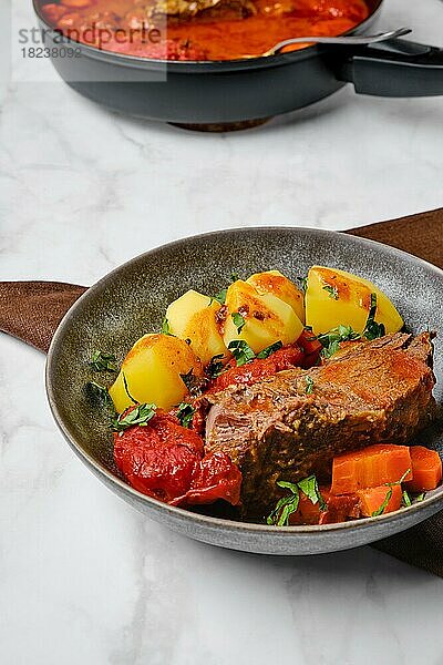 Langsam kochendes Essen. Roastbeef in Biersoße mit Tomaten und Karotten gebacken
