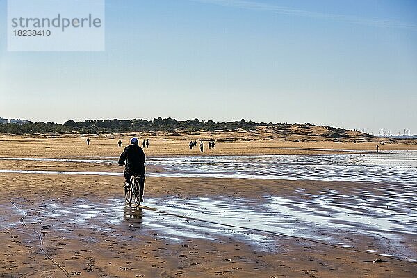 Einheimischer Fahrradfahrer und Spaziergänger am Strand  Plage Tagharte  Küstenlinie  Essaouira  Marokko  Afrika