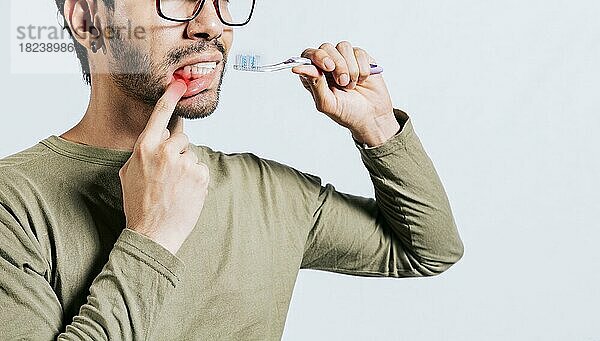 Menschen halten Zahnbürste mit Zahnfleischschmerzen. Mann hält Zahnbürste mit Zahnfleischschmerzen  Menschen halten Zahnbürste mit Zahnfleisch Problem isoliert. Junger Mann mit Zahnfleischentzündung hält Zahnbürste