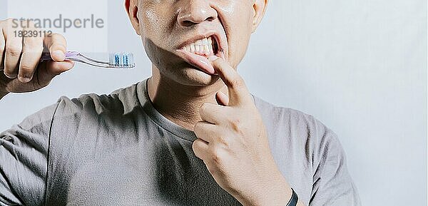 Person mit Zahnfleischentzündung hält Zahnbürste. Menschen halten Zahnbürste mit Zahnfleischschmerzen. Mann hält Zahnbürste mit Zahnfleischschmerzen  Menschen halten Zahnbürste mit Zahnfleisch Problem isoliert