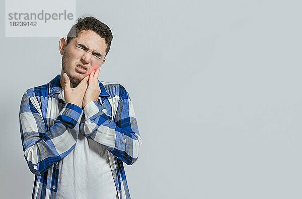 Mann mit Zahnschmerzen oder Pulpitis. Konzept der Menschen leiden unter Zahnschmerzen  Junger Mann mit Empfindlichkeit und Zahnschmerzen isoliert. Zahnschmerzen und Empfindlichkeit bei Menschen