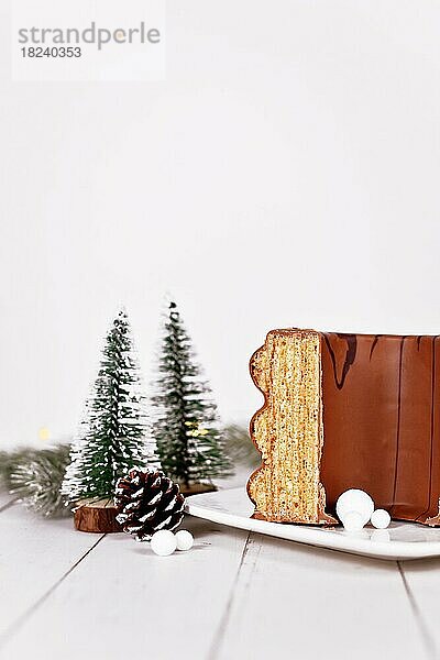 Traditioneller deutscher Baumkuchen  glasiert mit Schokolade  umgeben von jahreszeitlicher Dekoration