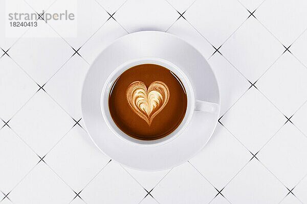 Draufsicht auf eine Tasse Kakao mit herzförmiger Milchkaffee-Kunst