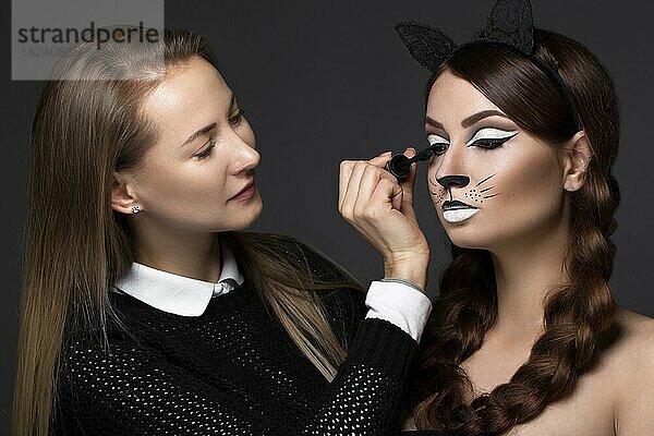 Zwei schöne Mädchen auf einem Foto-Shooting zu schminken  um das Gesicht. Schönheit Mode-Modell. Fotos im Studio geschossen