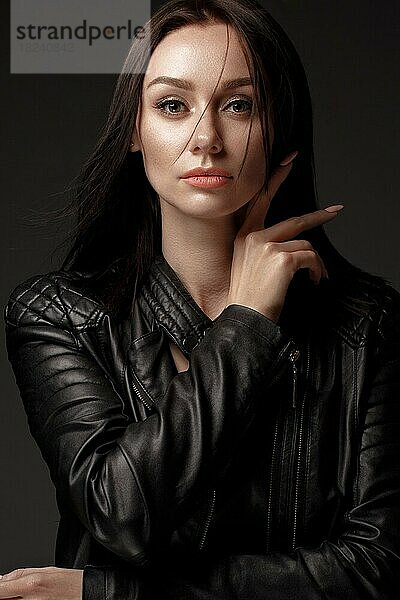 Gewagtes Mädchen Modell in schwarzem Lederkleid  Stil des Rock  dunkles Make-up und Schönheit Haar. Bild im Studio aufgenommen
